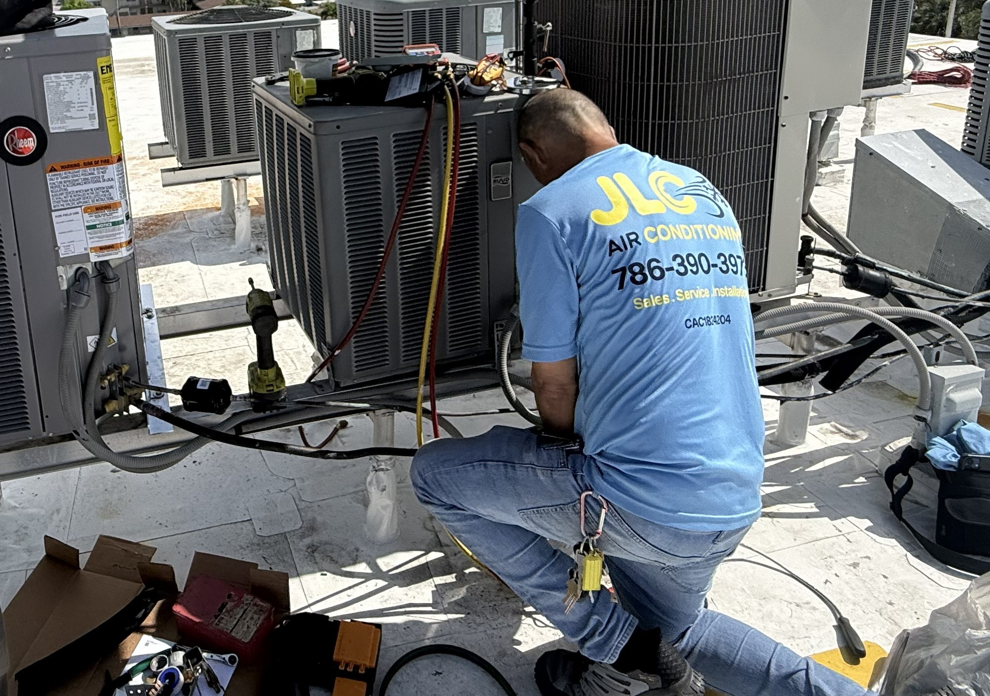 JLC technician servicing commercial rooftop air conditioning equipment